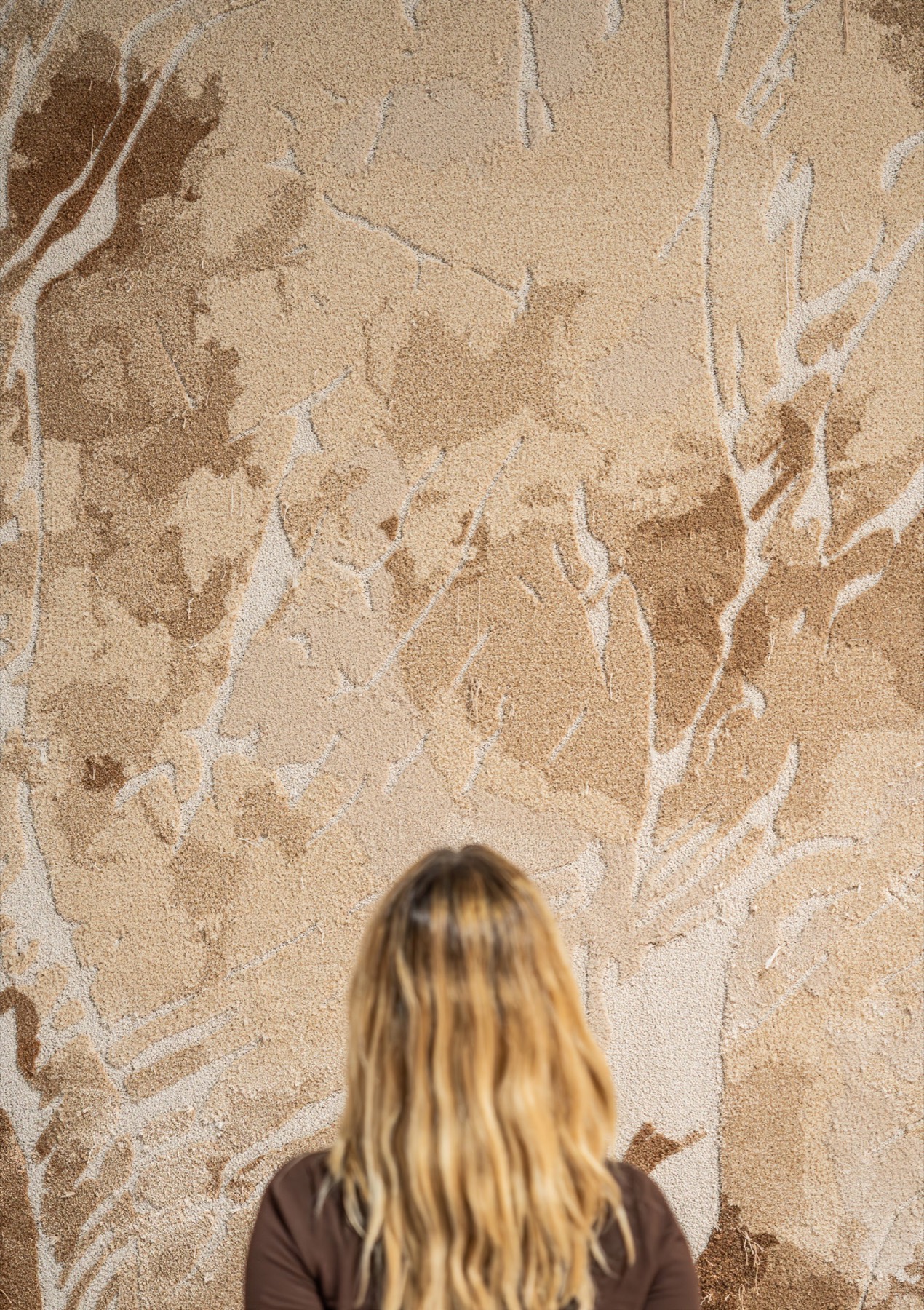 A visitor standing before a sculptural CORVO rug