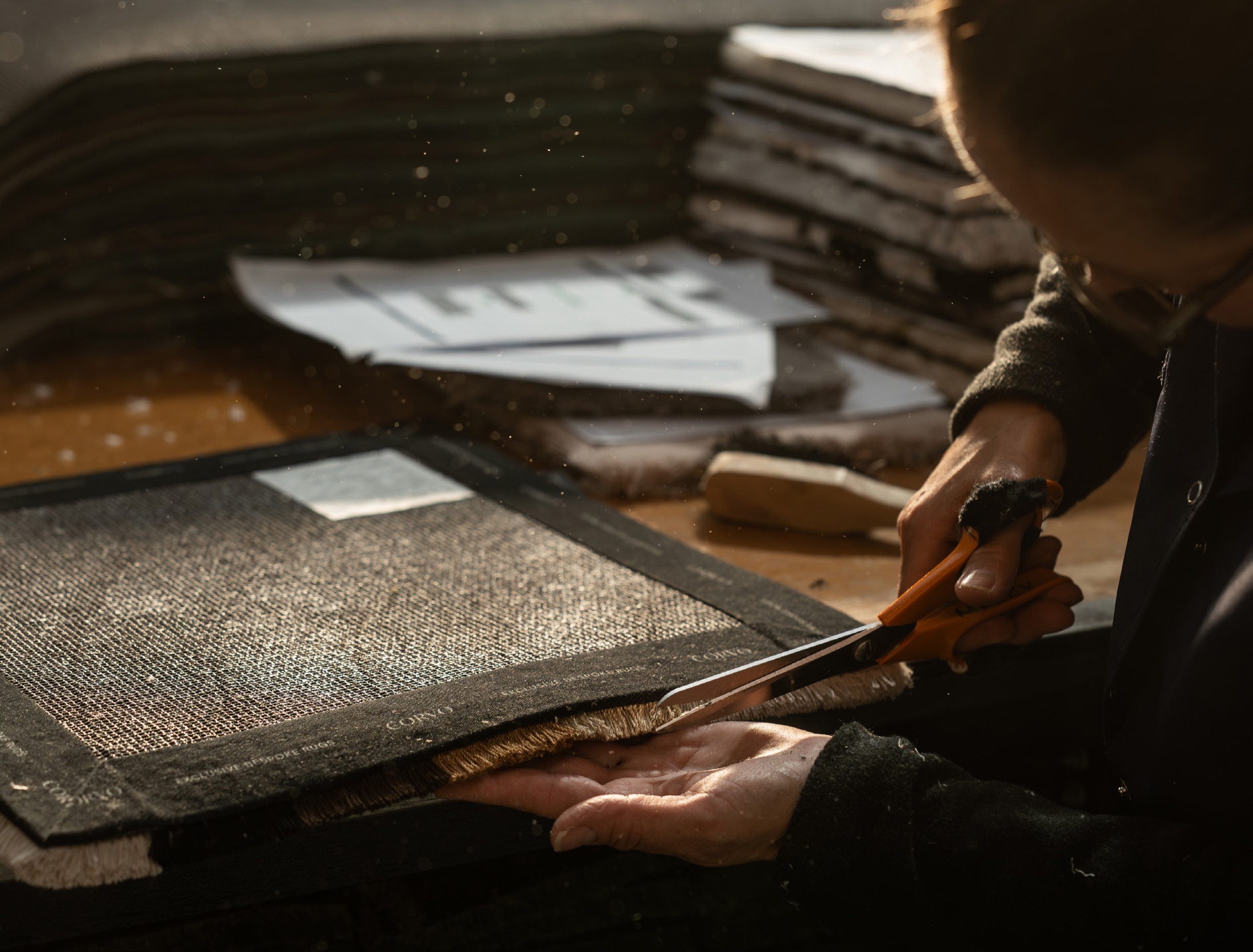 Hands finishing a CORVO exclusive bespoke rug in the atelier